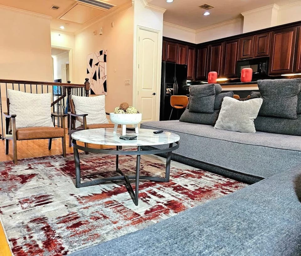 "Stylish comfort underfoot: Experience the plushness of the red, and grey area rug, complementing the modern design of the living room and providing a cozy ambiance."