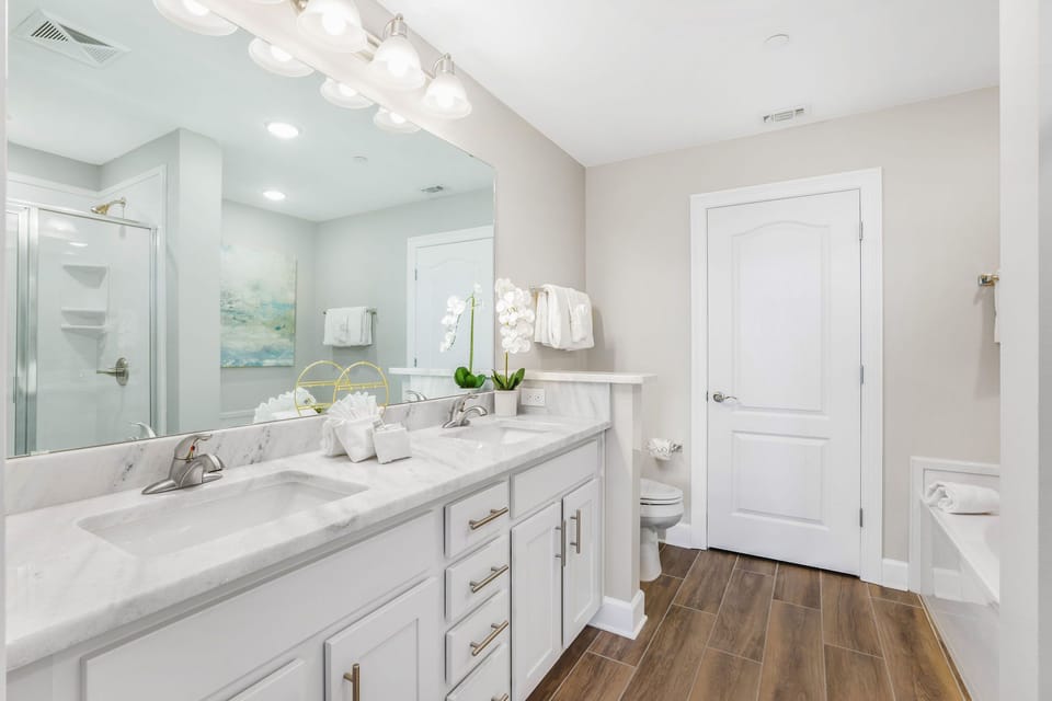 Freshen up at the marbled double vanity under soft lights, then unwind in the glass shower or deep tub in the master bath
