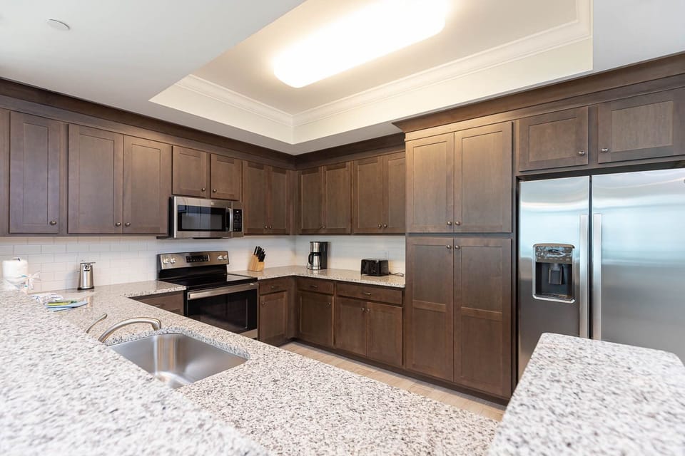 Prepare meals in this stylish kitchen with rich cabinetry, stainless appliances, and spacious counters