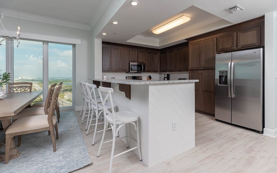 Gather and enjoy gulf coast views through the floor-to-ceiling windows from this inviting kitchen area