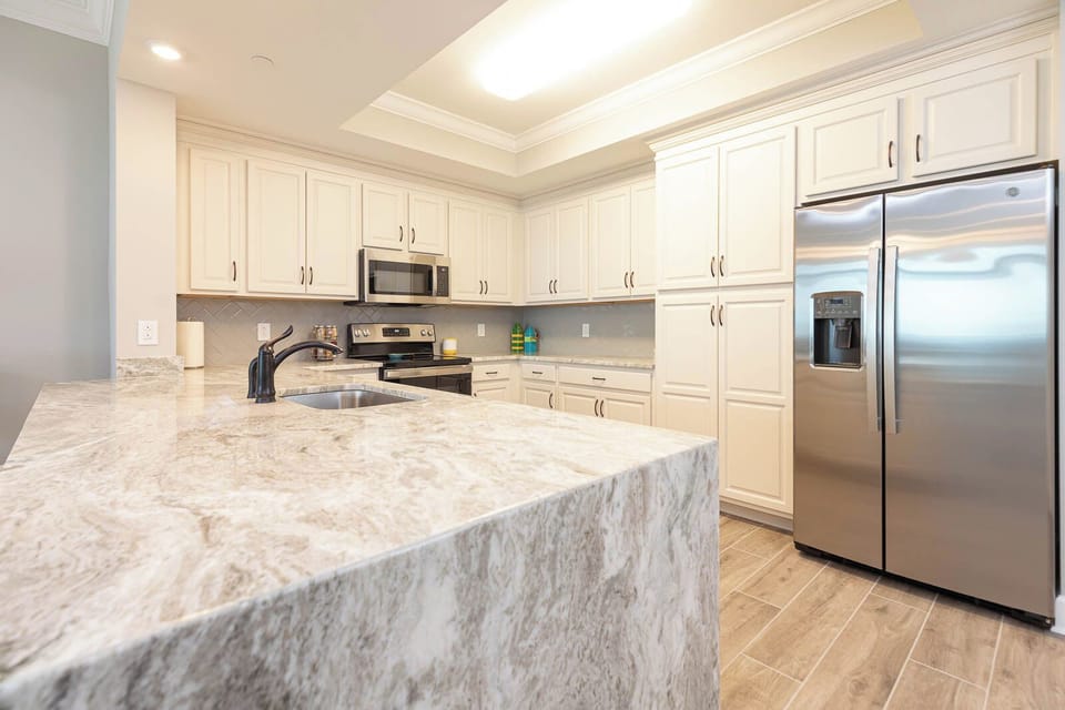 Imagine prepping meals on this spacious marbled counter while stainless appliances complement this space