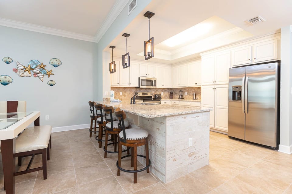 Perch on a bar stool beneath pendant lights and chat over coffee at the granite kitchen counter