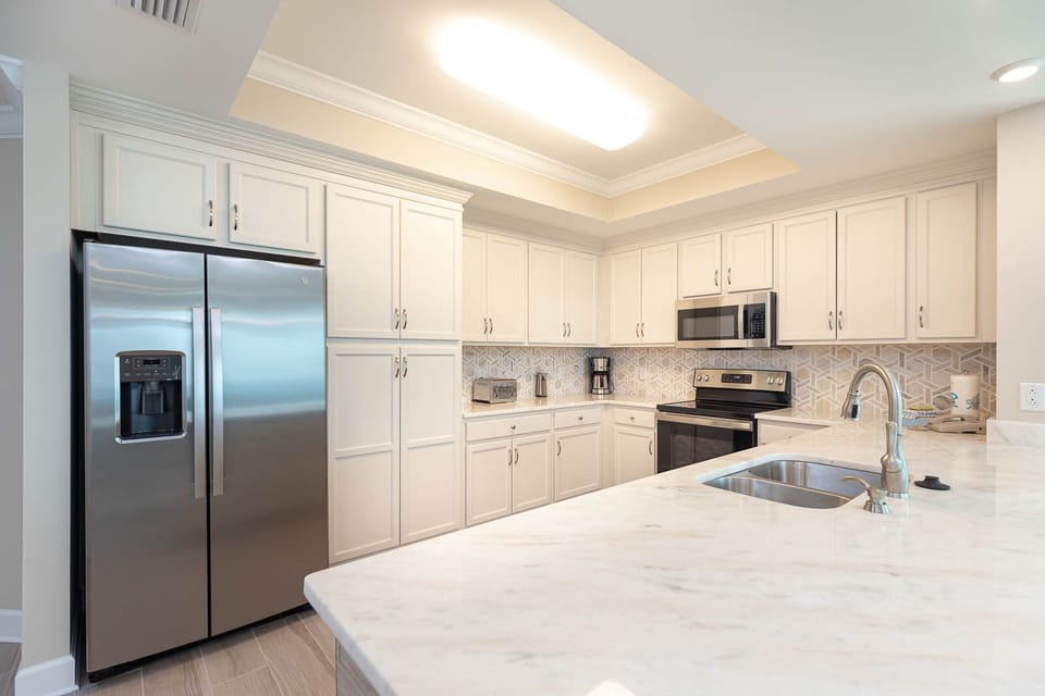 Prepare meals in this kitchen with elegant cabinetry, stainless appliances, and spacious countertops