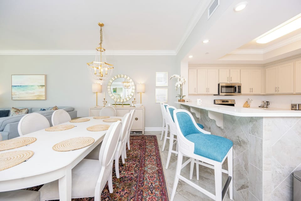 Settle onto teal-cushioned bar stools and enjoy the morning light in this elegant dining and kitchen area