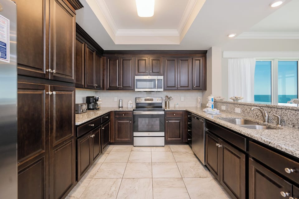 Brew morning coffee or prepare meals in this elegant kitchen with wooden cabinetry and stainless appliances
