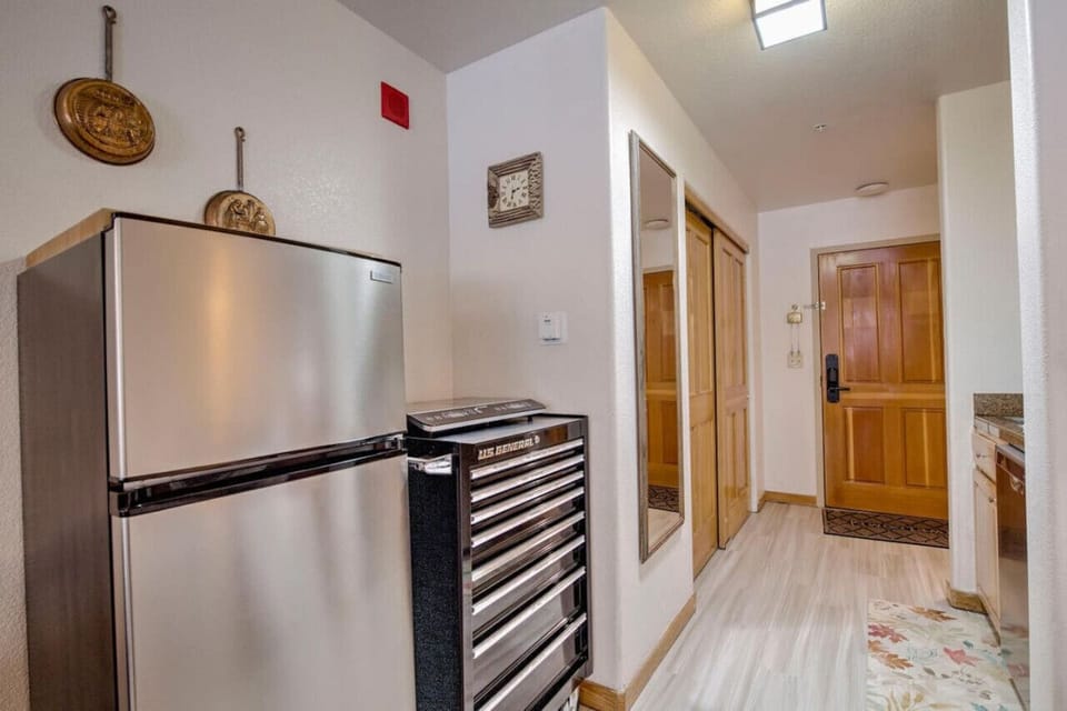 Small kitchen area with a refrigerator/freezer and kitchen items