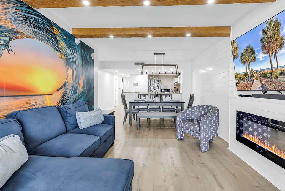 Enjoy the living room space with wooden beams, Alexa-controlled motorized blinds, an electric fireplace, and a 70" LG Smart TV.