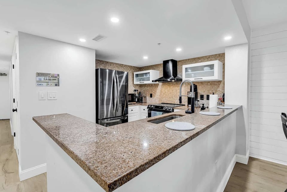 New Kitchen with Black stainless-steel appliances, vented hood, induction cooktop w/air fryer, microwave, toaster, all utensils and more.