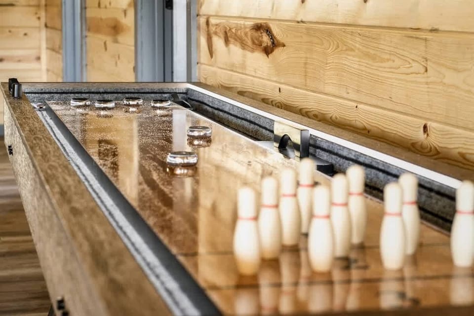 Indoor shuffleboard table with wooden walls for a rustic game experience