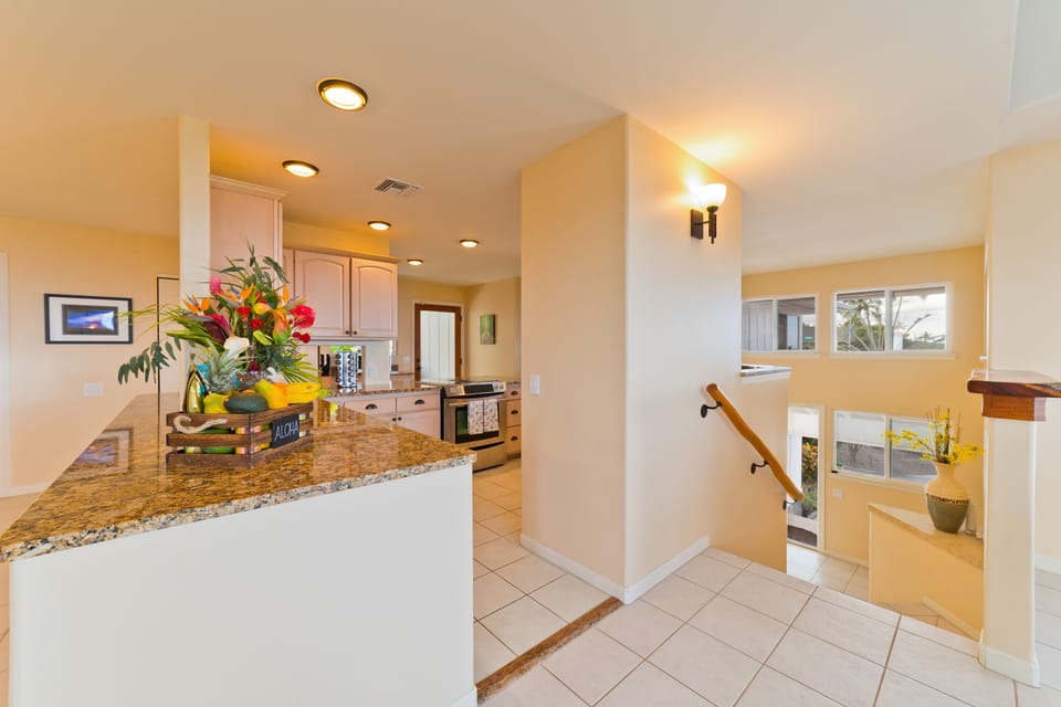 Top of staircase looking towards kitchen and down the stairs to the entrance.