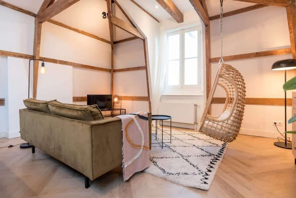 The living area has a TV, and the large window lets in plenty of natural light