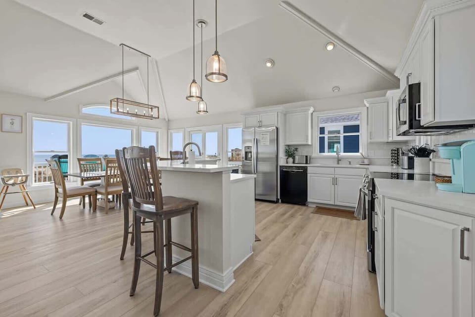 Nicely equipped kitchen with panoramic ocean view has refrigerator, stove, microwave, two dishwashers, blender, Keurig coffee maker, toaster, pots and pans, plates, glasses, wine glasses, coffee cups, spices, cooking and eating utensils.