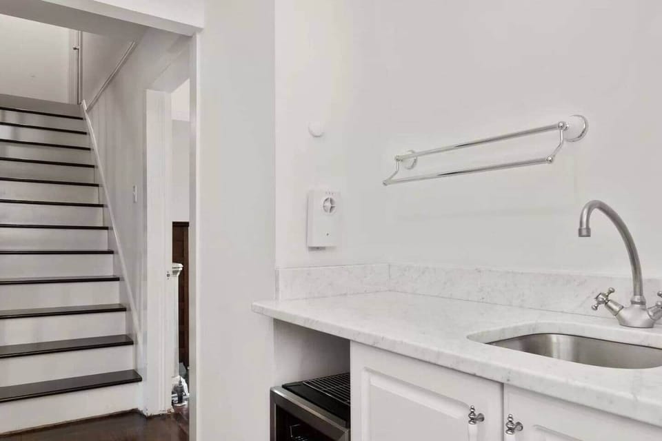 Upstairs hallway wet bar with wine refrigerator and electric kettle coffee/tea.