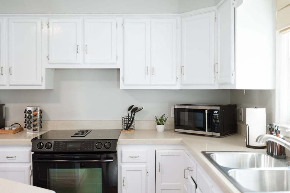 Modern kitchen fully equipped with appliances, cookware, spices, and a Keurig Duo coffee maker