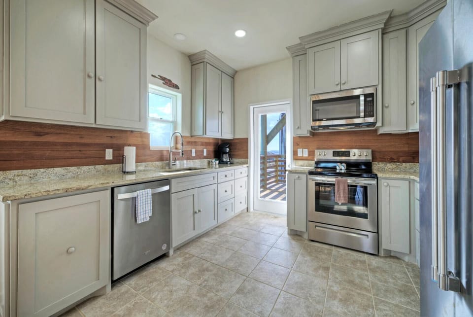 Kitchen is fully equipped and features modern stainless steel appliances.