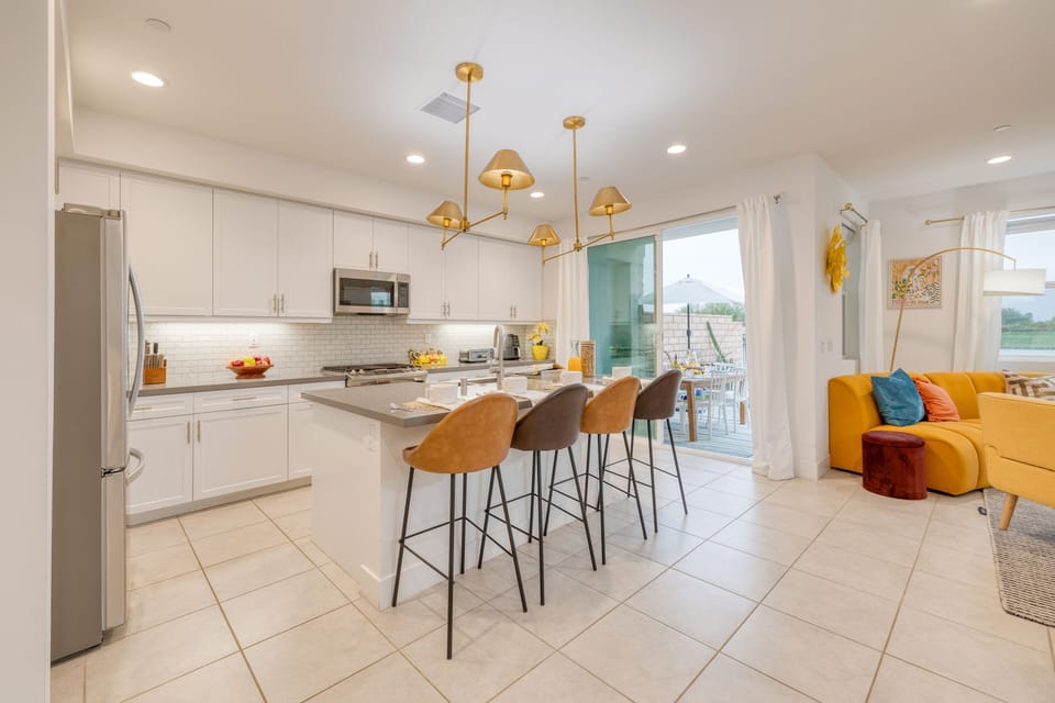 Kitchen features an island with barstool seating.