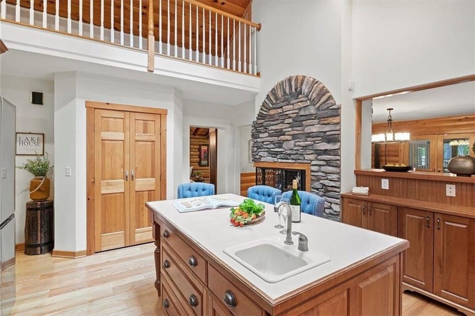 Luxuriate in the open-plan space of this elegant kitchen, complete with a majestic stone fireplace and a mezzanine that promises cozy evenings with wine and games.