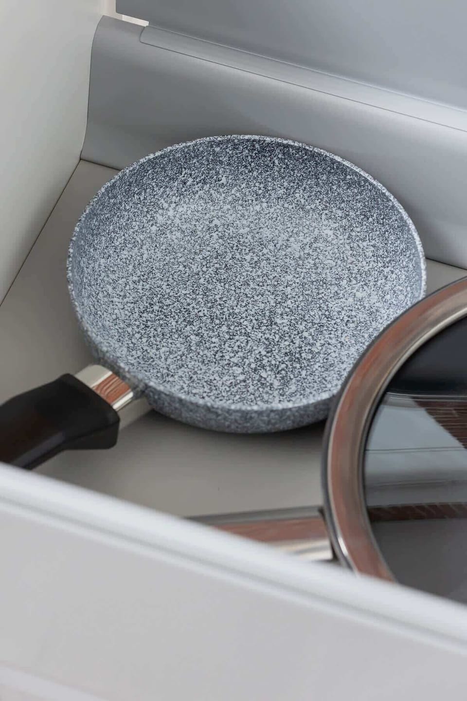 A close-up of a modern kitchen sink with a stylish black pan, showcasing attention to detail in kitchen essentials.
