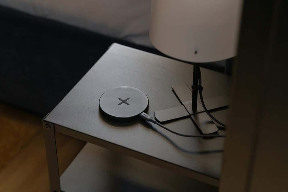 A close-up of a small side table, possibly with a wireless charger or decorative lamp, adding a practical touch to the room.
