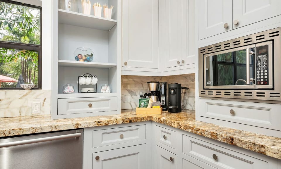 Modern kitchen corner with granite countertops and built-in microwave