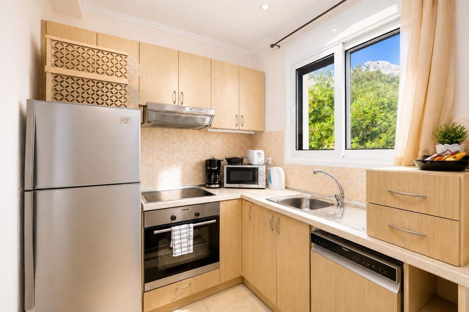 Bright modern kitchen with wooden cabinetry, full appliances, and lovely natural light.