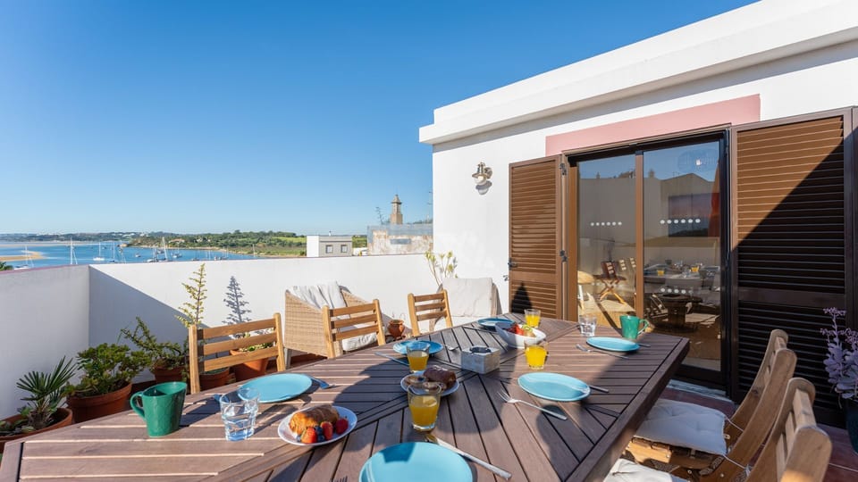 Enjoy breakfast al fresco on the rooftop terrace, soaking in the sun and panoramic views of the water.
#OutdoorDining #RooftopView #LovelyStay