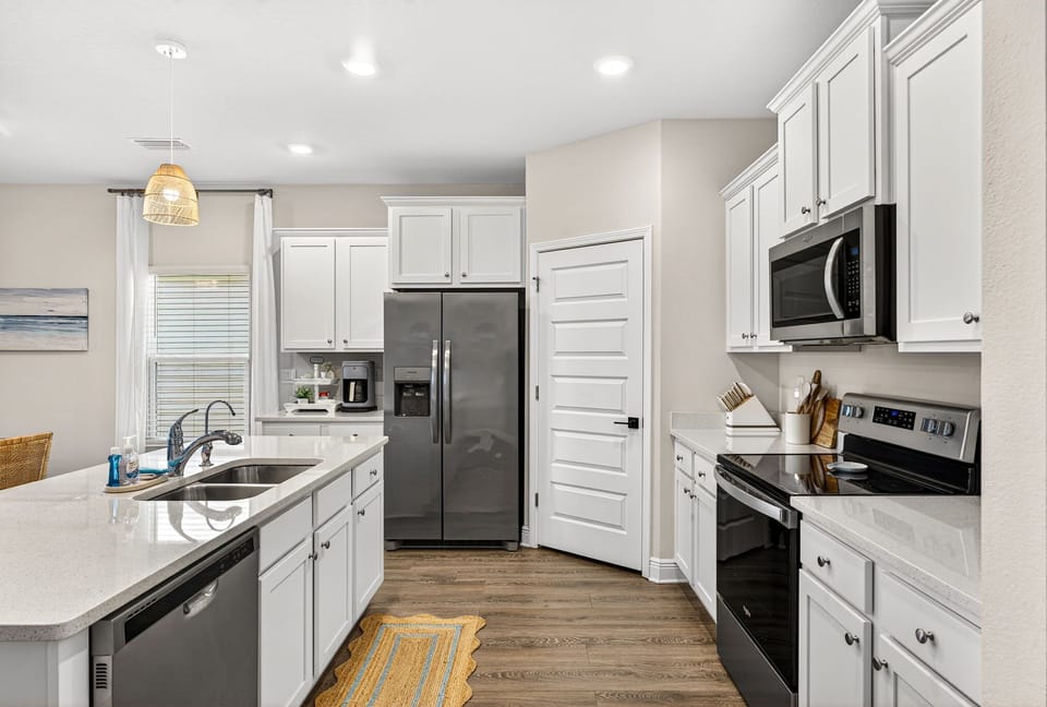 Step into your bright, modern kitchen with sleek white cabinetry, stainless appliances, and gleaming quartz countertops—ready for your morning coffee or a cozy meal together.