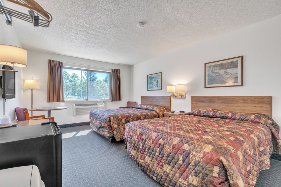Unwind in this spacious room, tailored for families or groups. Two luxurious Queen-sized beds provide a restful retreat, complete with wardrobe storage for outdoor gear, a coffee maker, and a mini fridge. Comfort and convenience are at your fingertips.