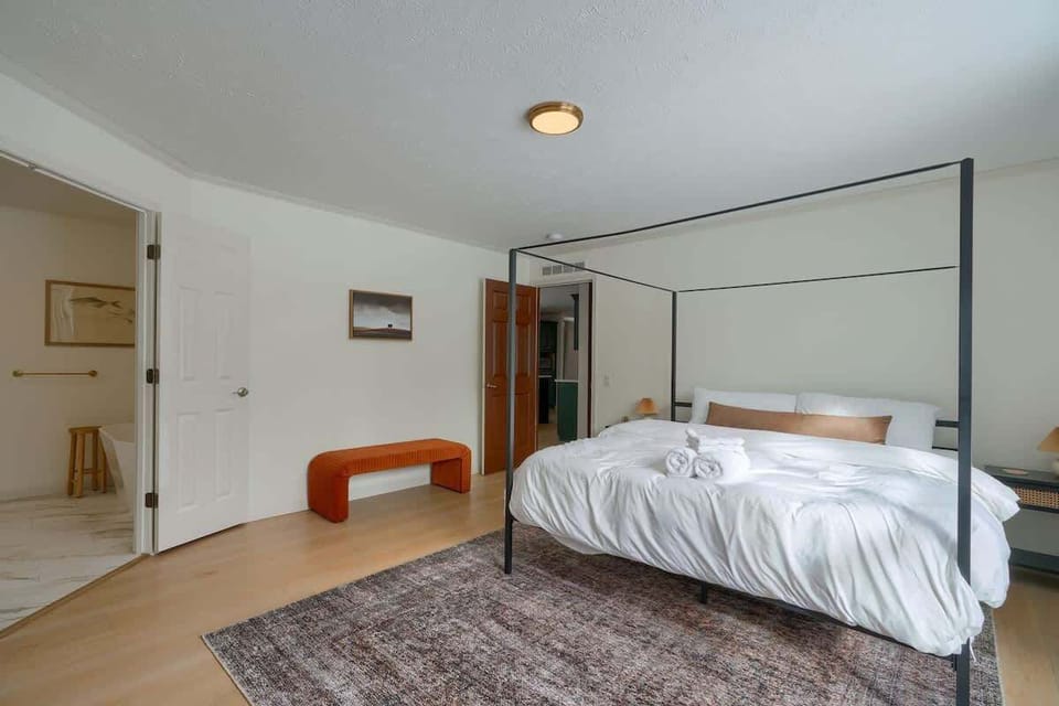 Main Floor Bedroom: Stylish retreat with a four-poster bed and serene decor for a perfect getaway!