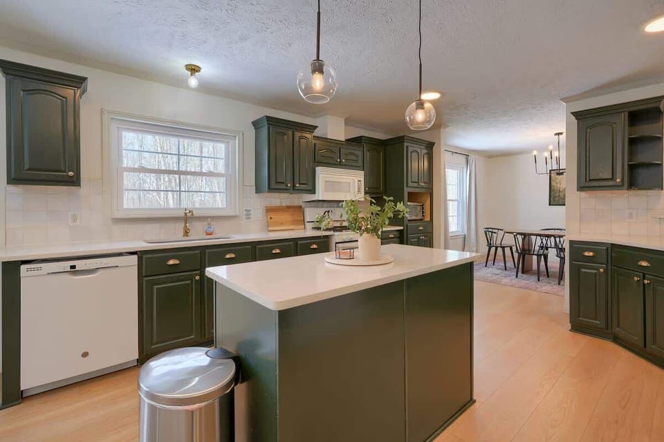 Kitchen: Stylish green cabinetry and a bright island invite culinary adventures and gatherings!