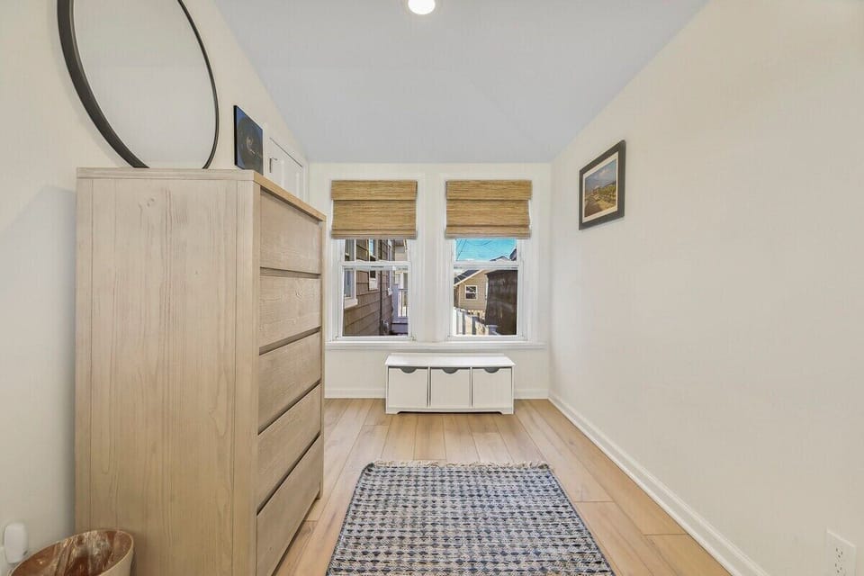 Bright & Cozy Nook: This inviting space is ideal for unwinding. Enjoy the natural light from two windows, ample storage in the stylish dresser & bin, and soft rug underfoot.