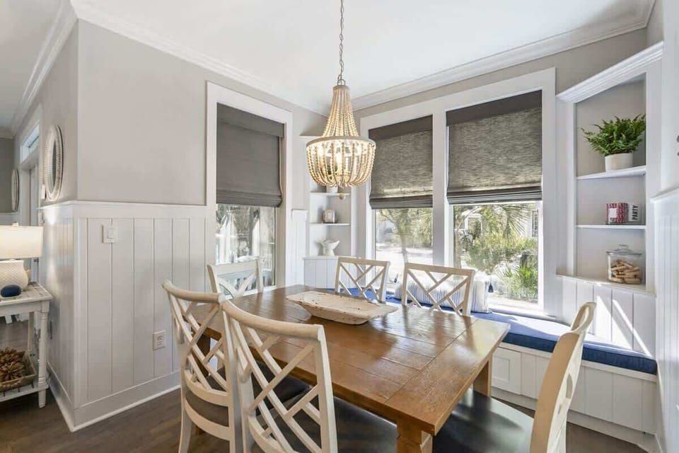 - Beautiful dining nook featuring a cozy window seat and a charming chandelier - Built in shelves add a personal touch, creating a warm and inviting space - Perfect spot for enjoying meals or relaxing with natural light streaming in