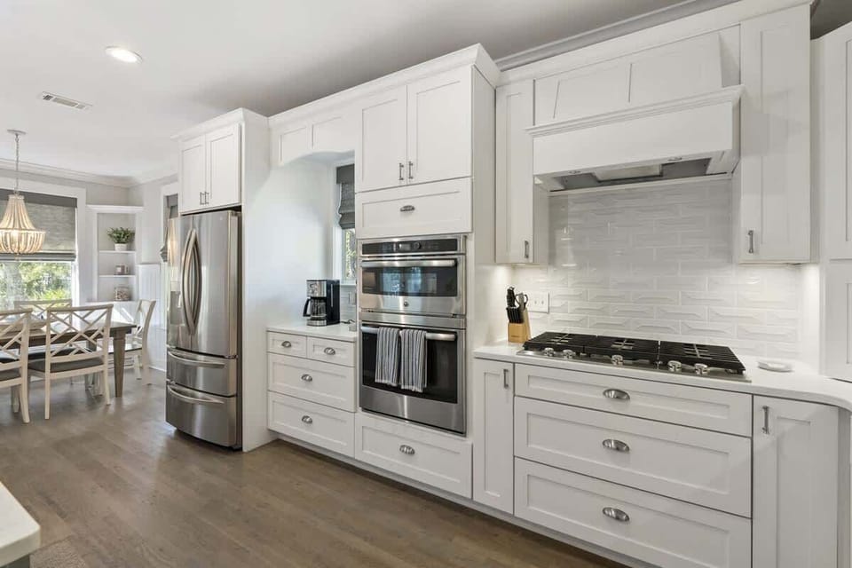 - Sleek and modern kitchen with top of the line appliances and plenty of counter space - White cabinetry and subway tile backsplash add a fresh, clean look - Well designed space for cooking, with easy access to the living and dining areas