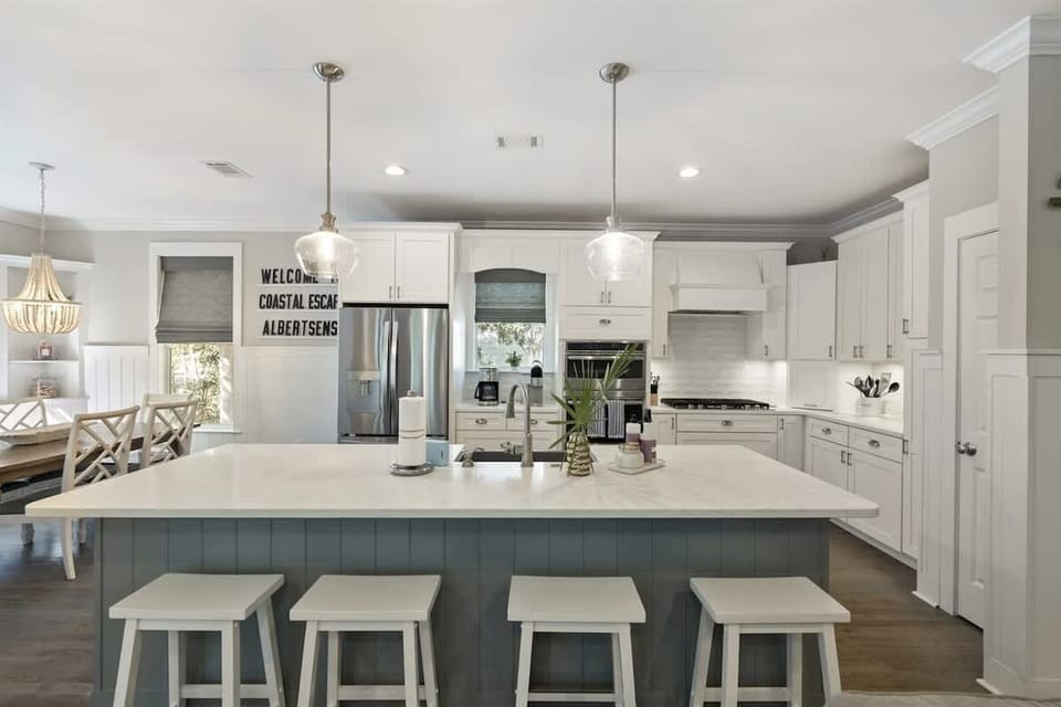 - Stylish kitchen island with seating, perfect for casual dining or chatting while cooking - Modern appliances, white cabinetry, and beautiful lighting create a fresh, inviting space - Perfect combination of style and function in this open, airy kitc