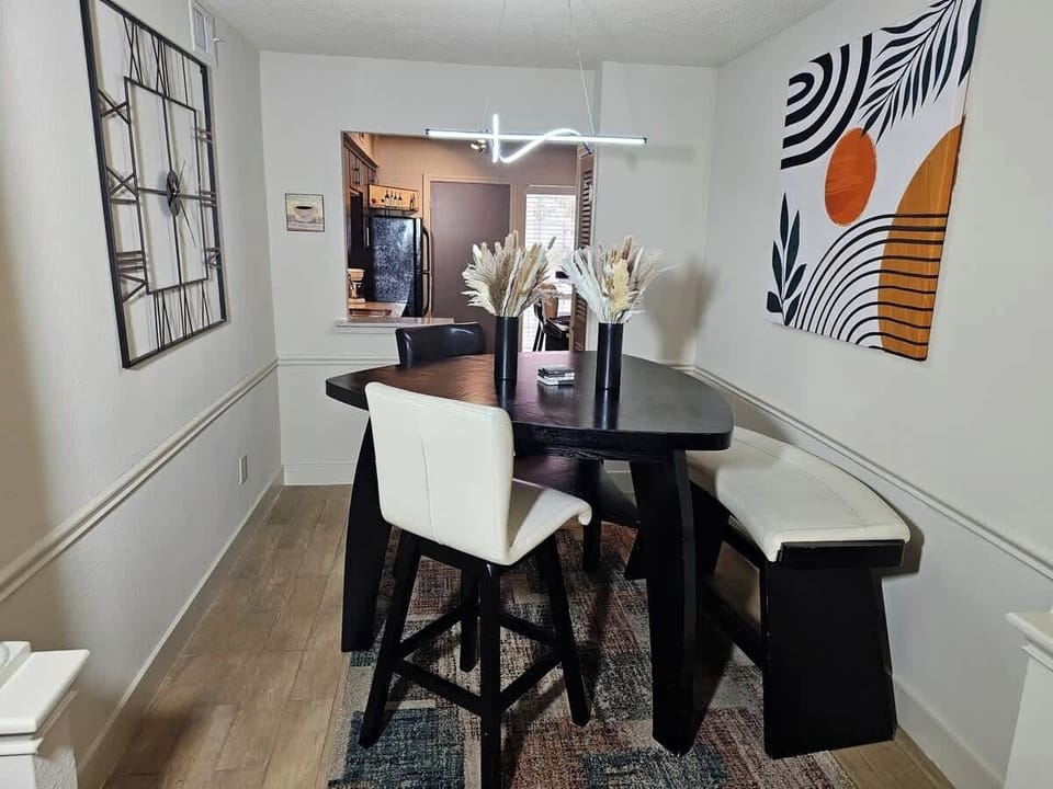 Dining Room:  Gather around a diamond-shaped dining table, where sleek bar stools and a cozy bench offer versatile seating options for intimate dinners or lively gatherings.