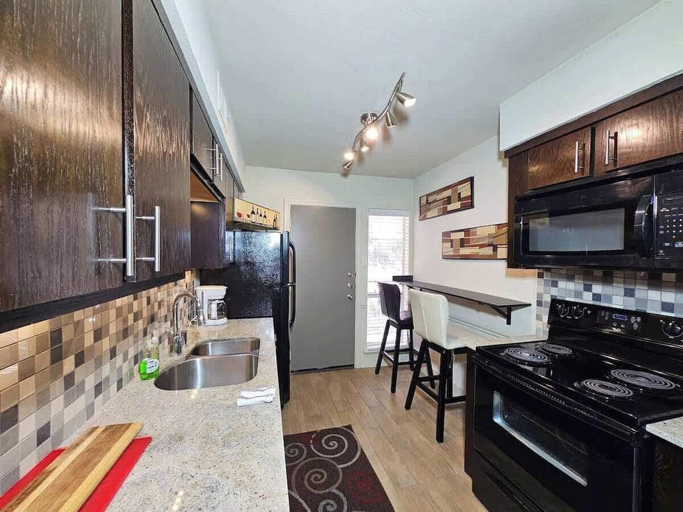 Kitchen: Start your day in style in this modern kitchen with a sleek breakfast bar, perfect for enjoying your morning meal or catching up on work.

