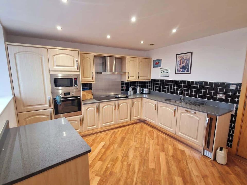 Our fully fitted kitchen includes an oven, hob, microwave, fridge freezer, wine chiller, washer dryer, dishwasher, and a complete set of kitchen utensils for your convenience.