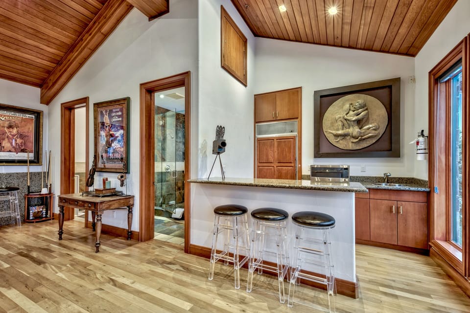 Wet bar in the game room with refrigerator and sink. Also his and hers bathrooms. Mens bathroom has a Urinal.