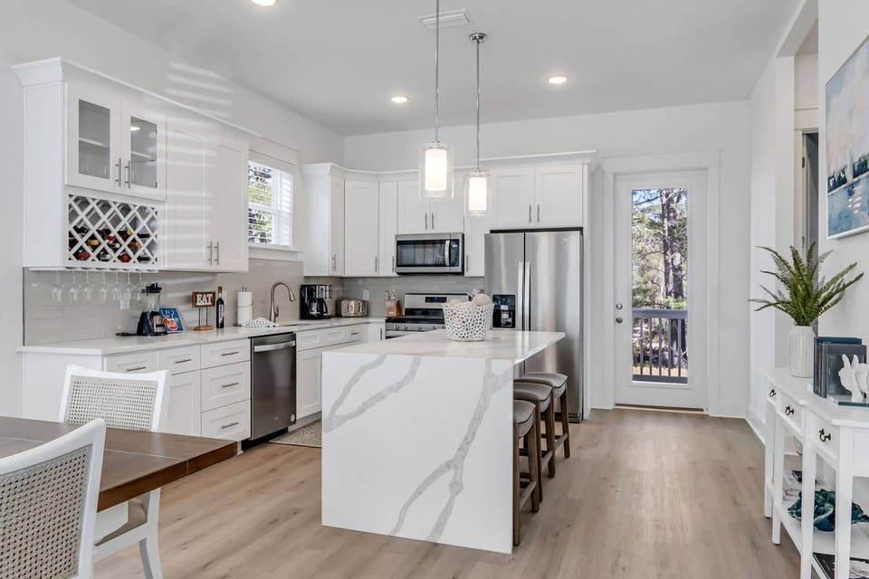 The kitchen offers beautiful quartz countertops with stainless appliances, a dining table with seating for up to 8 guests, w/4 more seats at the bar