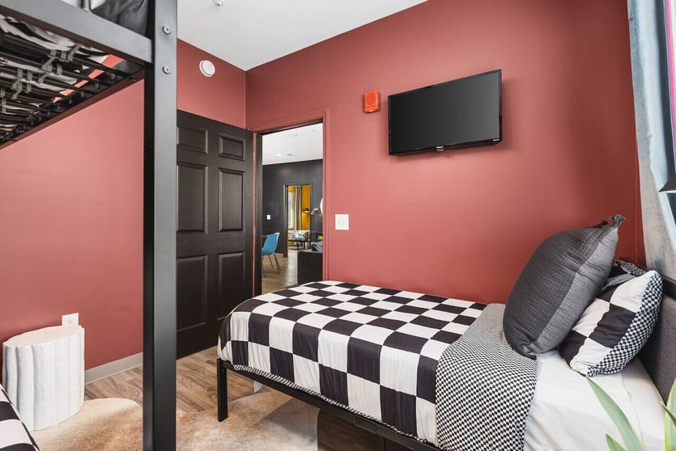 Bedroom #2 with Queen-over-Queen bunk beds, a Twin bed, a Smart TV with all the apps, and room-darkening shades. There's also a hanging space for you to keep your clothes.