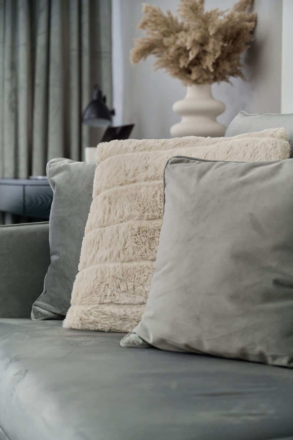 A close-up of decorative pillows in different textures and neutral colors.
