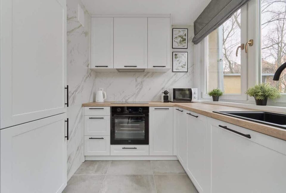A compact but functional kitchen with elegant finishes and ample storage space.
