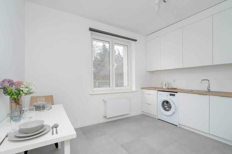 A cozy kitchen corner with a dining table and a view of the greenery outside.
