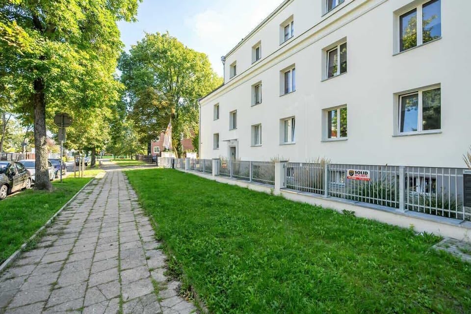 The surrounding outdoor area, with a grassy lawn, a walking path, and a well-maintained facade.
