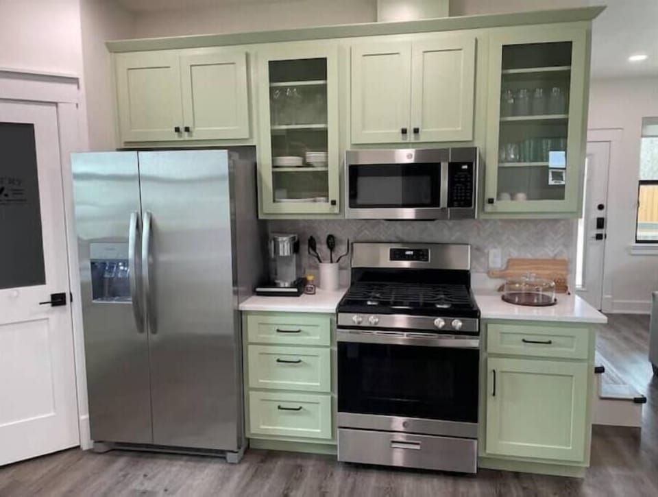 Kitchen w/ gas stove, microwave, Keurig, and refrigerator.