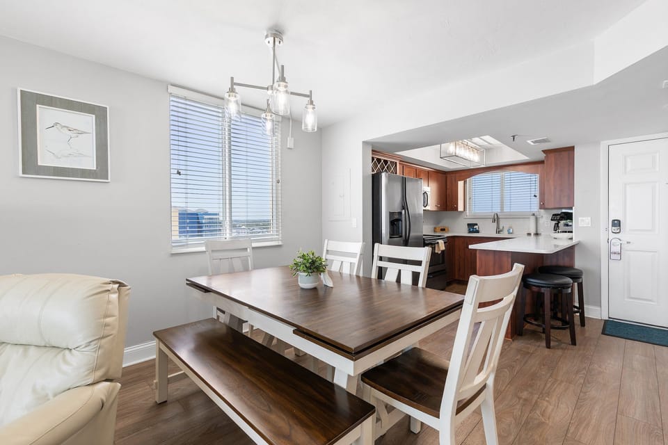 Gather for meals in this bright coastal dining area overlooking the fully equipped kitchen with breakfast bar. The open layout creates the perfect space to connect, dine, and enjoy a relaxing beach stay with family and friends.