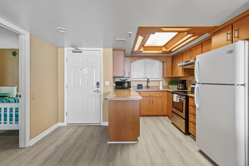 Fully equipped kitchen with granite countertops, ample storage, and a modern design.