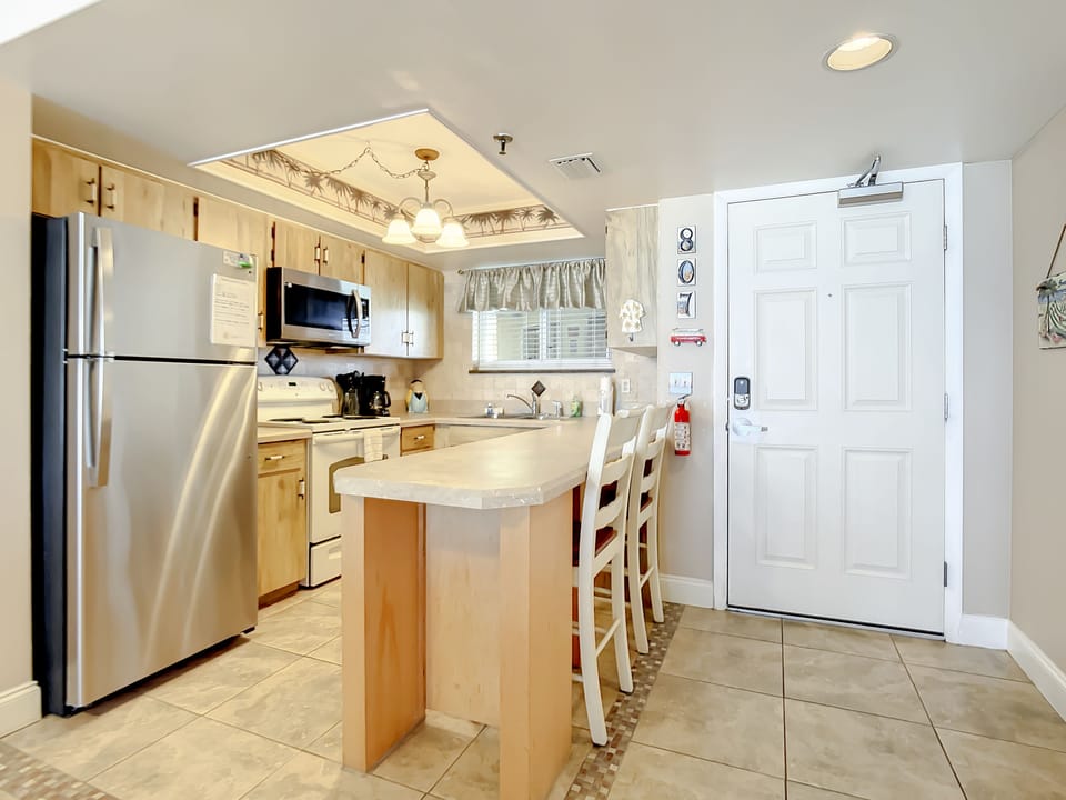 Fully equipped kitchen featuring a breakfast bar and stainless steel appliances.