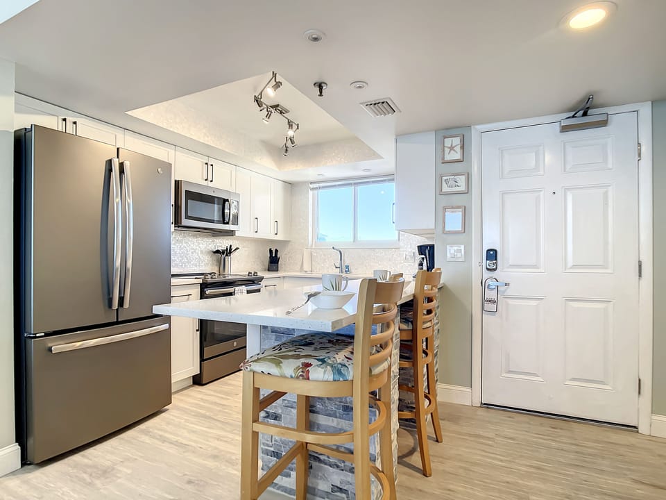 Sleek kitchen design featuring stainless steel appliances, a breakfast bar, and plenty of natural light.