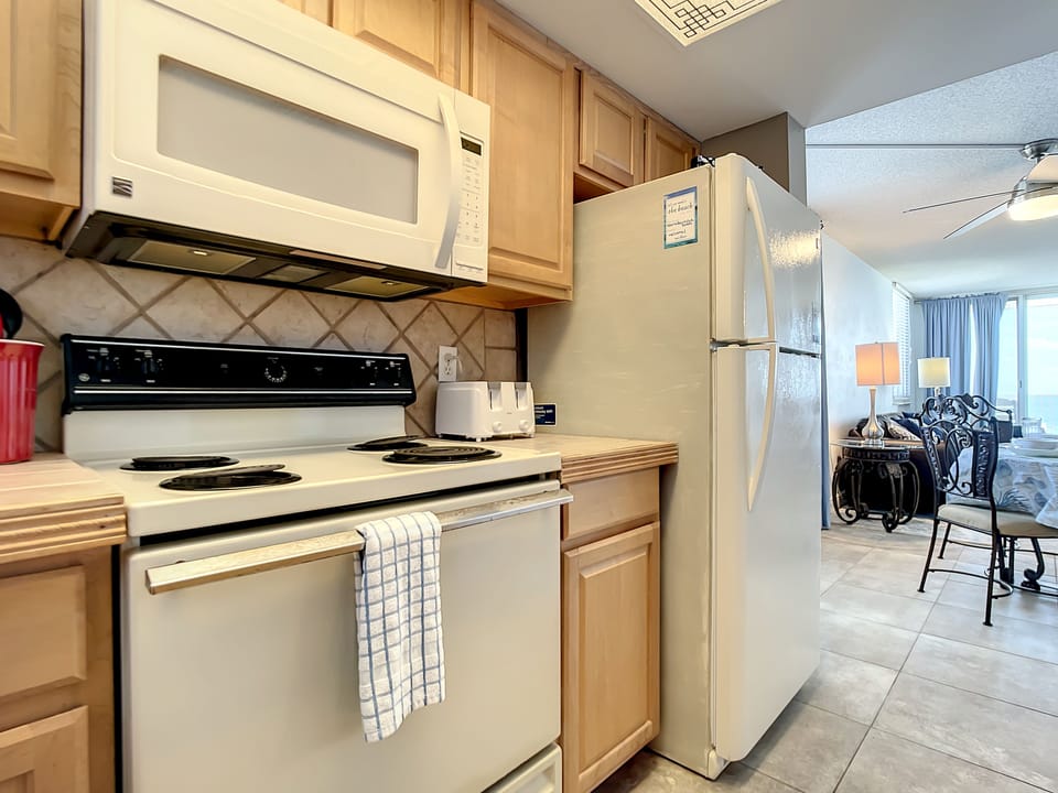 Includes stove, microwave, and spacious refrigerator, blending convenience with a home-like feel.